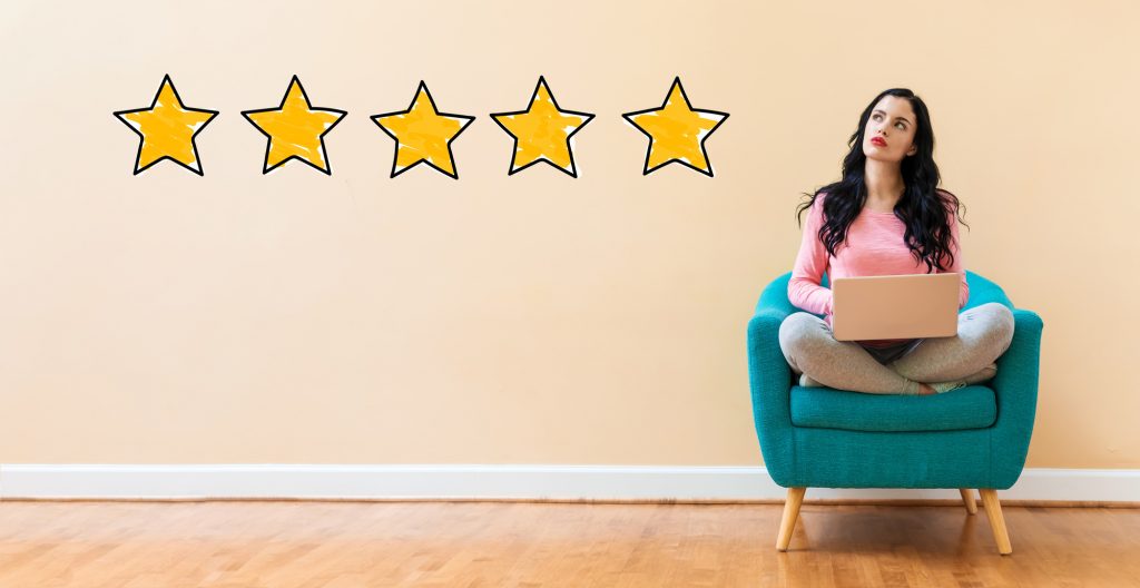 review stars and woman on chair with computer
