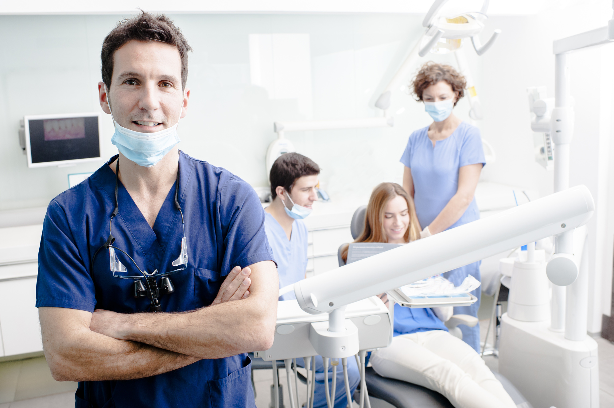 Dentist and His Assistants with a Patient