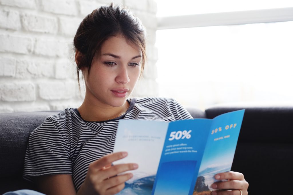 Person Reading a Direct Mail Advertisement Pamphlet